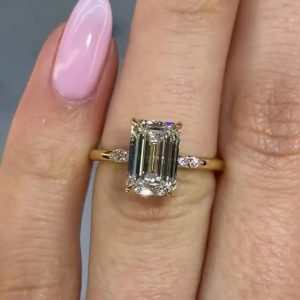 Emerald-cut diamond engagement ring with hidden halo and side stones