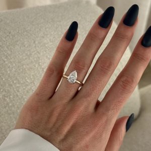 East-west pear diamond engagement ring with pavé basket and plain band