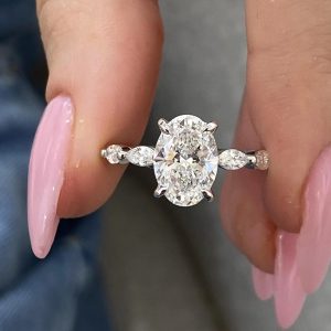 Oval diamond engagement ring with side stones and pave basket