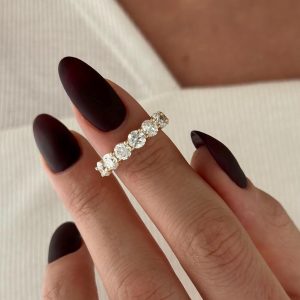 Five round diamonds set in a shared prong ring atop a classic band