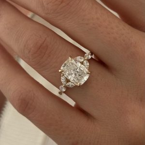 Cushion-cut engagement ring with marquise and round cluster side stones in a three-stone design