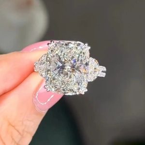 Cushion halo engagement ring with pavé band and trapezoid side stones