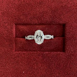 Oval engagement ring with four prongs and twisted pavé shank